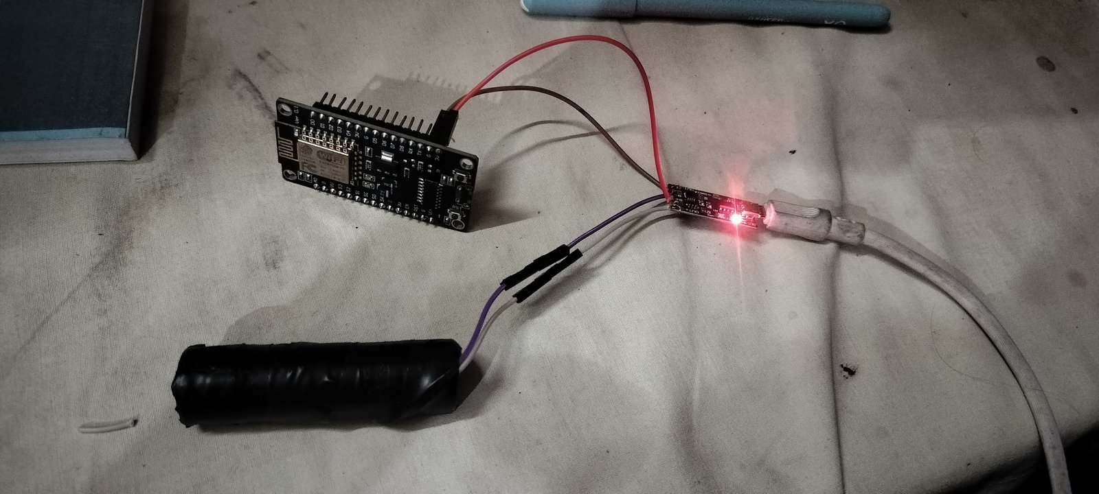 Figure 1: Early bench experimentation with an ESP module, TP4056 charging board, and lithium cell power rail.