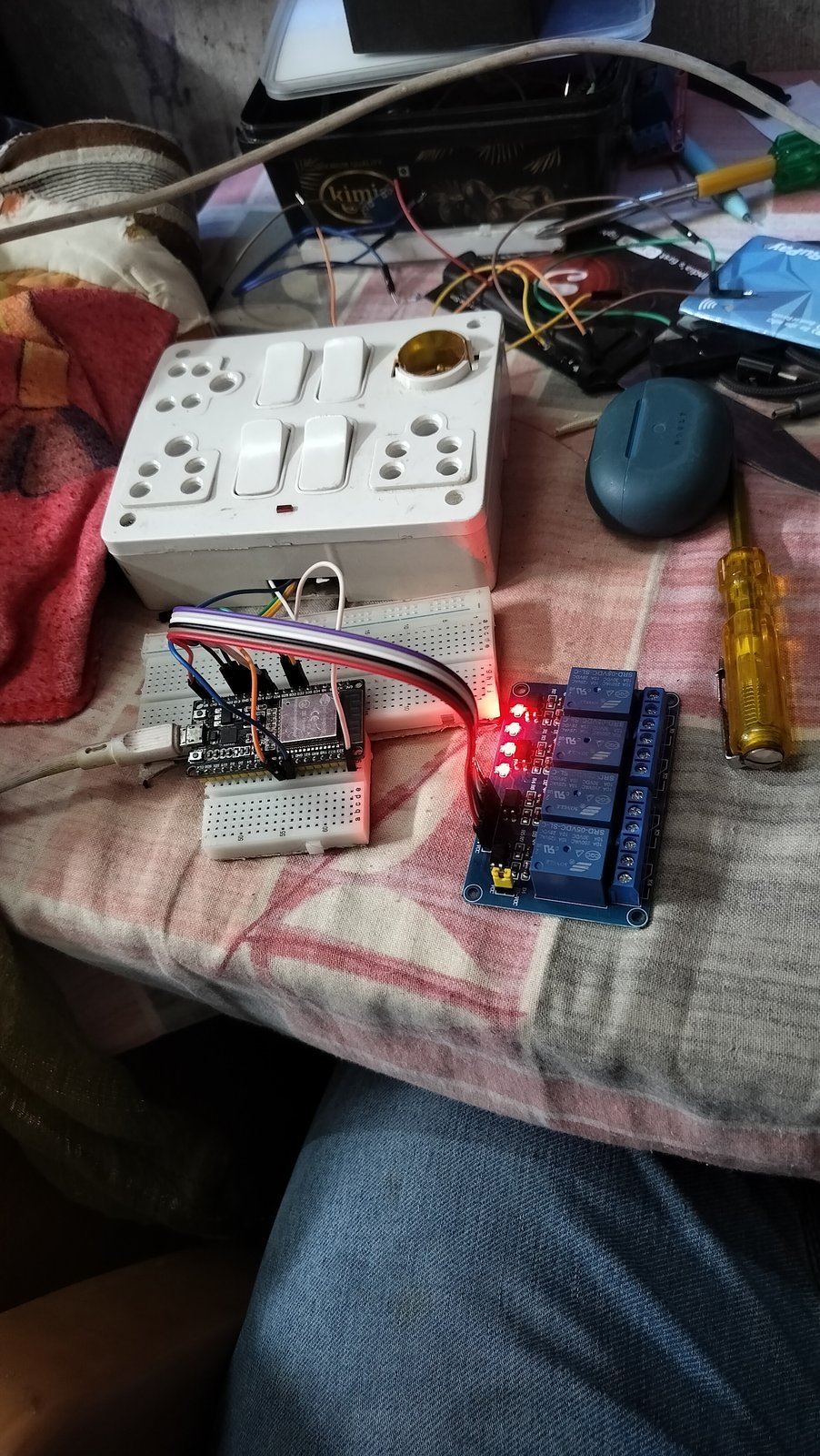 Figure 2: The physical Smart Switch test bench: 4-gang Indian modular switchboard connected via low-voltage signal wiring to an ESP32 Dev Module and 4-channel optocoupled relay board.